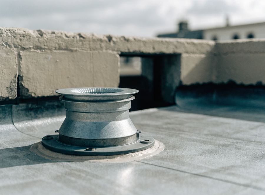 A roof drain with its clamping ring, set into flat roof membrane. Illustrative photograph.